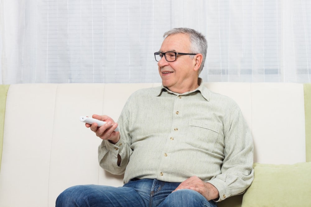 Mand er ser film i sit hjem